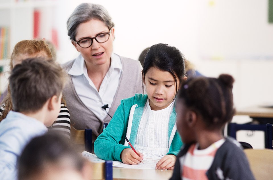 Children being helped by teacher