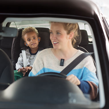 Woman wearing Connectclip hearing aid accessory in the car