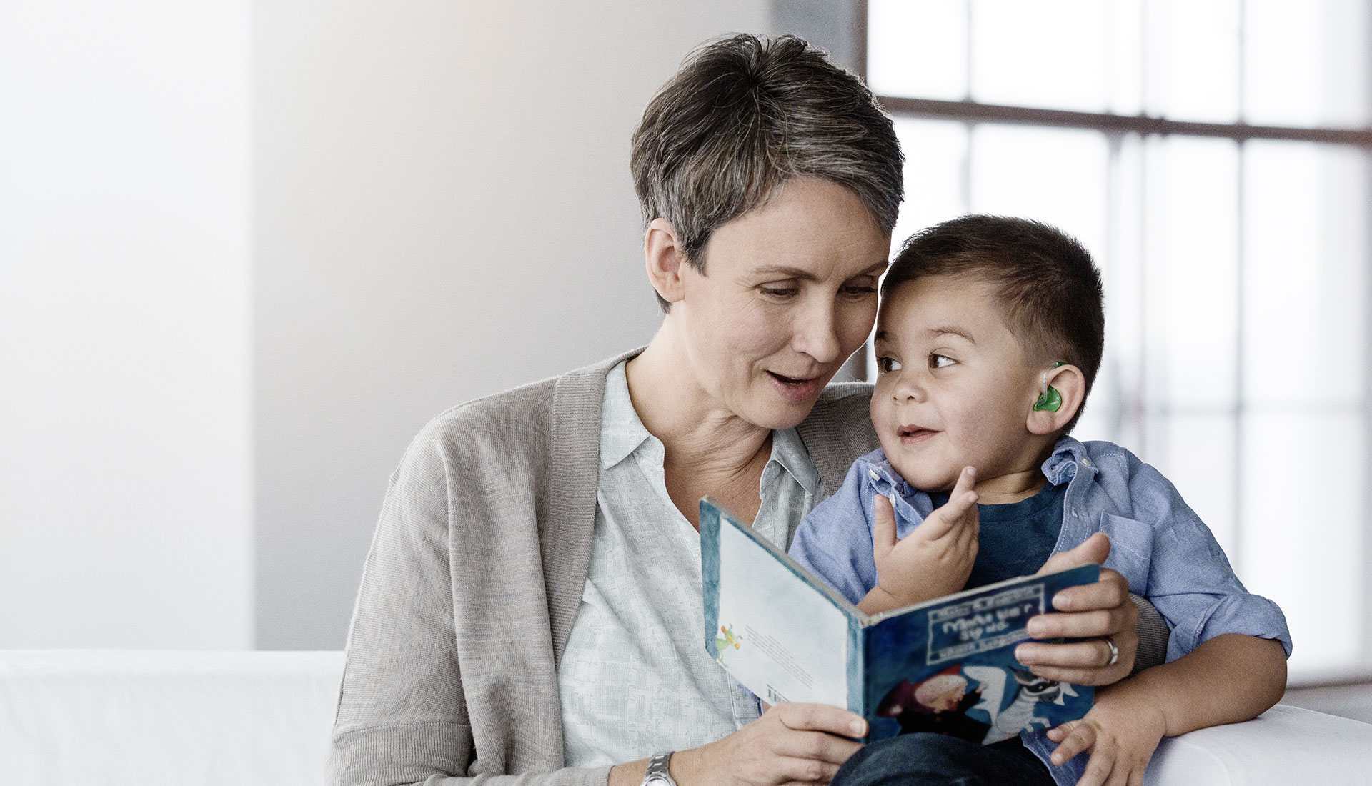 woman reading a book to a young boy